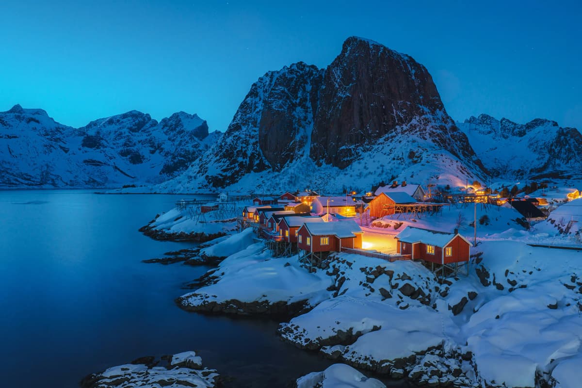 Panorama serale su un villaggio norvegese con case rosse illuminate dalla luce del tramonto, immerso nella neve, durante un’esperienza unica nell’anno all’estero in Norvegia.