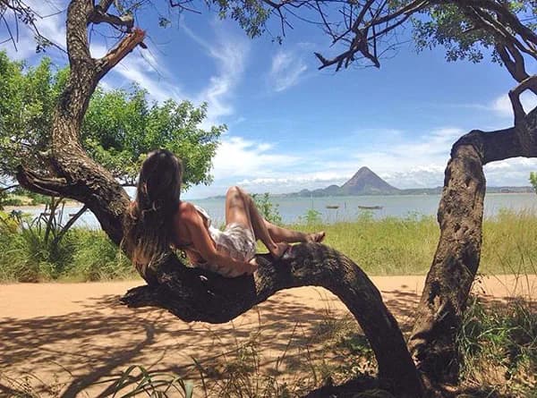 Studentessa si rilassa nella natura brasiliana vicino a un lago, simbolo dell’equilibrio e del tempo libero durante un anno all’estero in Brasile.