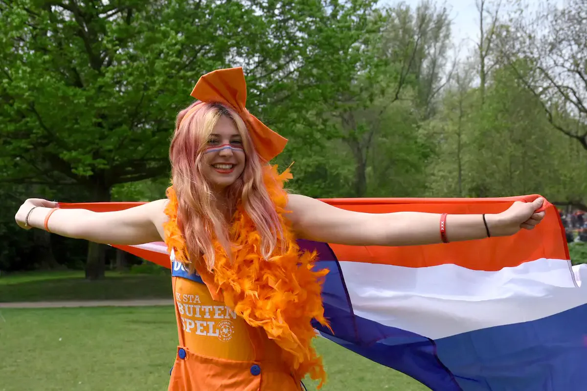 Studentessa festeggia con la bandiera olandese durante l’anno all’estero nei Paesi Bassi, vivendo tradizioni locali e momenti di condivisione.