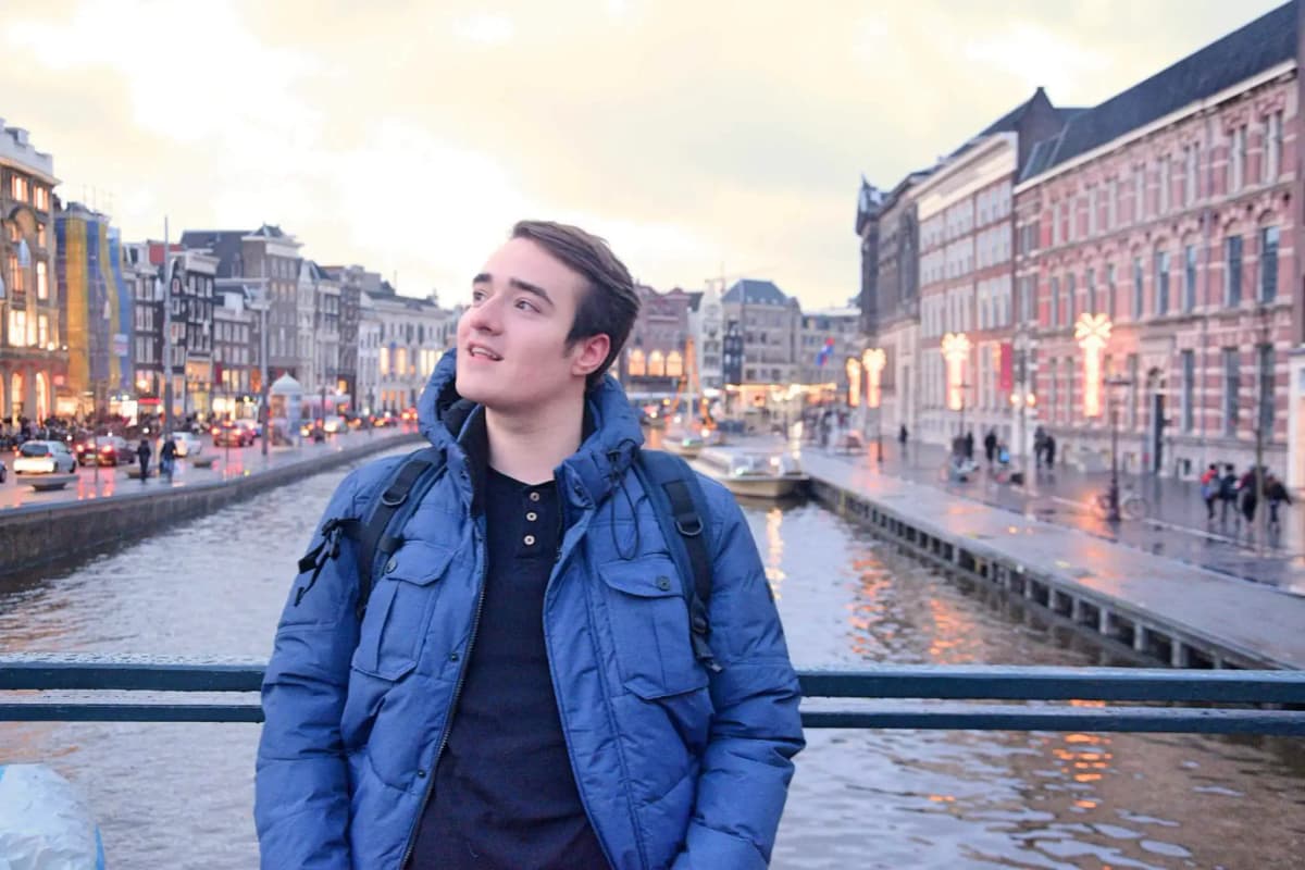 Studente lungo un canale olandese durante l’anno all’estero nei Paesi Bassi, immerso nella vita urbana e nell’atmosfera della città.
