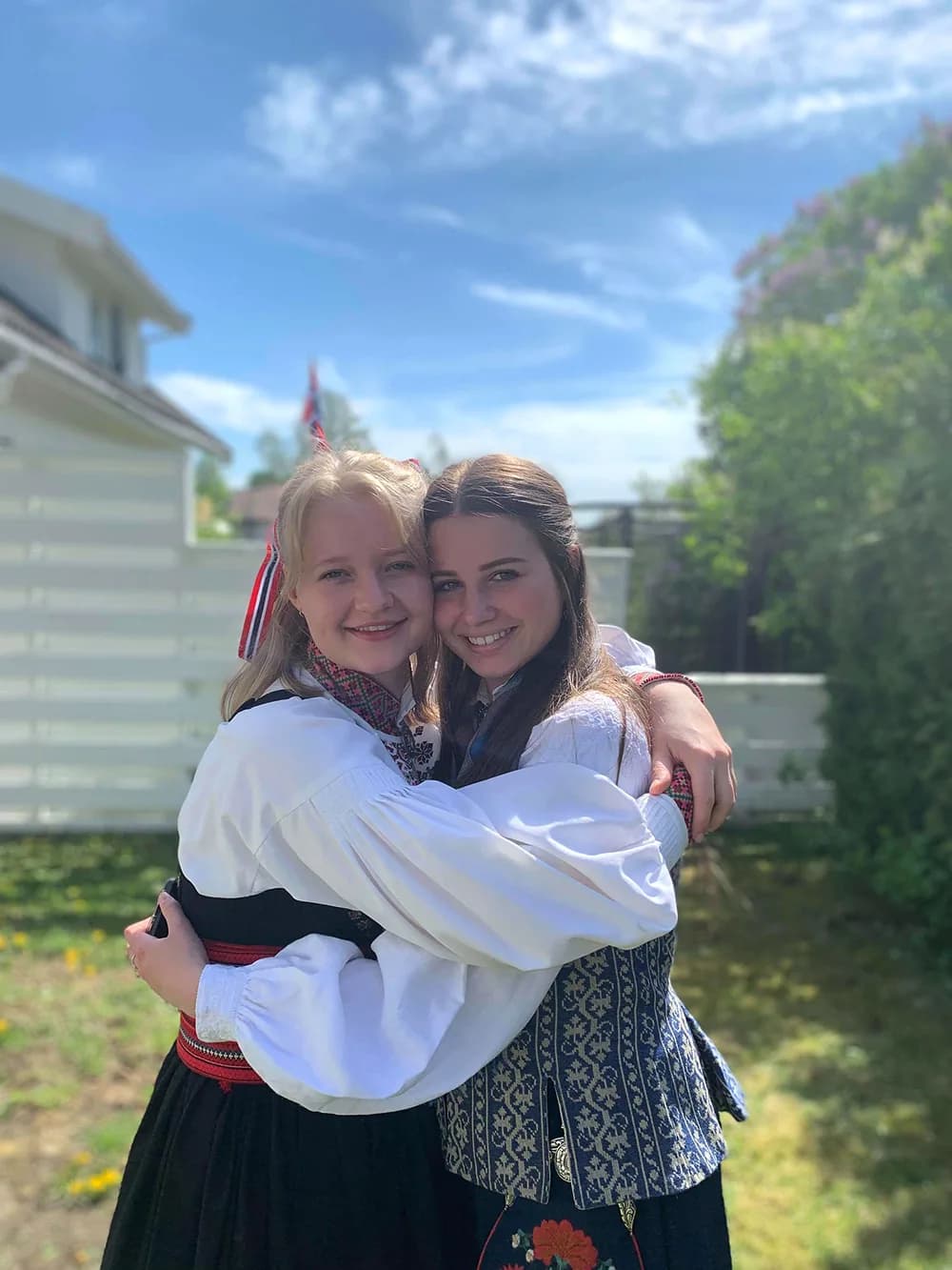 Due ragazze in abiti tradizionali norvegesi si abbracciano, vivendo un’esperienza di scambio culturale durante l’anno all’estero in Norvegia.