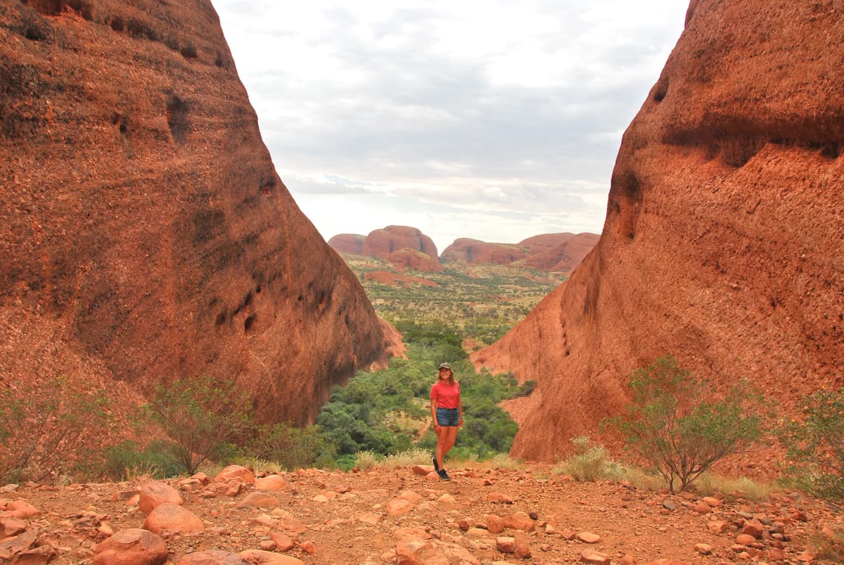 Studentessa tra rocce rosse nell’outback durante un Anno scolastico all’estero in Australia, esplorando paesaggi naturali.