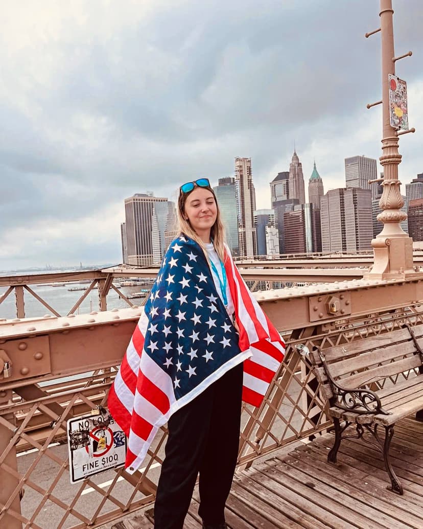Studentessa sul ponte di Brooklyn durante corsi di lingua a New York, con Manhattan sullo sfondo.