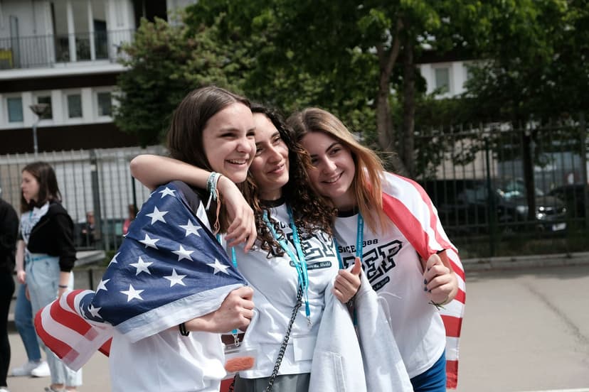 Studentesse abbracciate condividono un momento di amicizia durante un anno scolastico all’estero, tra scambio culturale, nuove relazioni e spirito internazionale.