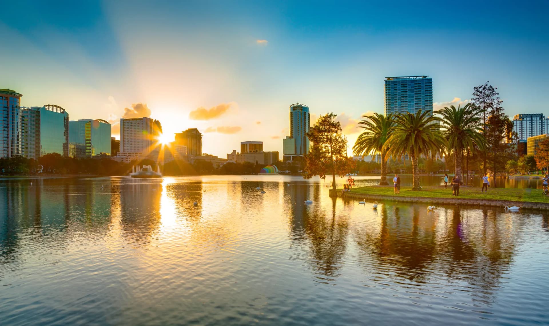 Skyline di una città americana con lago e palme al tramonto, contesto tipico dell’anno all’estero in USA e della vita urbana.