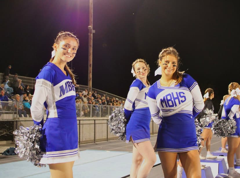 Cheerleader di una high school americana durante una partita serale, esempio di attività sportive e vita scolastica che si vivono in un anno all’estero in USA.
