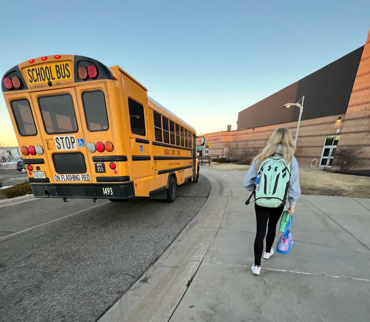 Studentessa davanti a uno school bus durante un anno all’estero USA, simbolo della quotidianità e della scuola negli Stati Uniti.