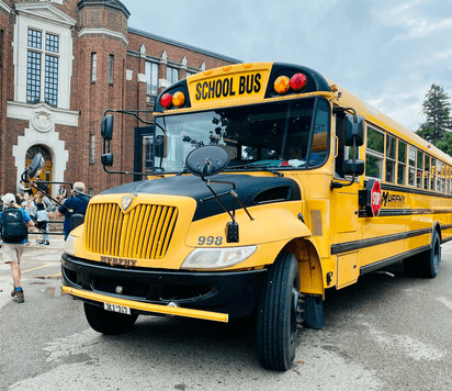 School bus giallo davanti a una scuola in Canada, simbolo della quotidianità durante un anno all’estero Canada nel sistema educativo locale.