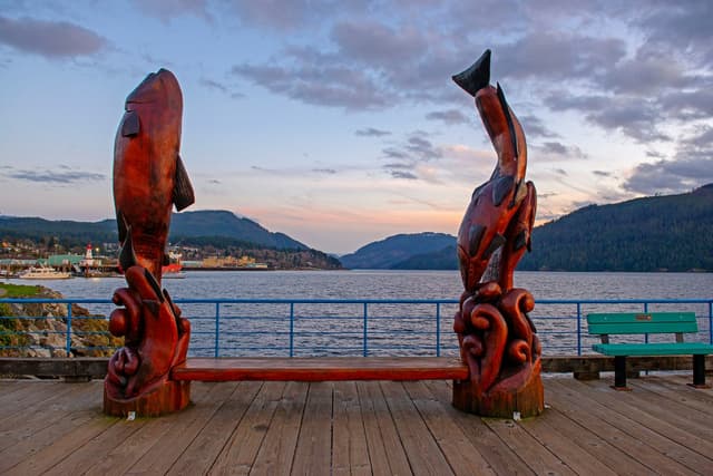 Sculture in legno sul lungomare con lago e montagne, paesaggio tipico vissuto durante un anno all’estero Canada.