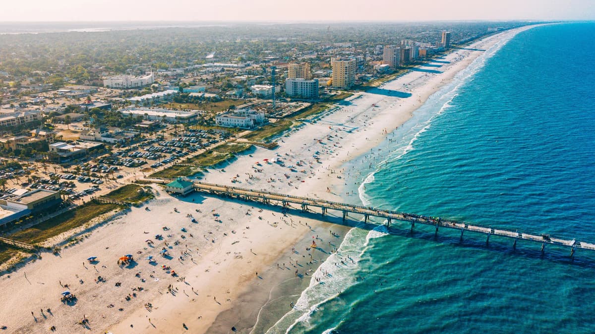 Veduta aerea di una città costiera negli Stati Uniti con spiaggia, oceano e molo, esempio di contesto urbano durante l’anno all’estero in USA.