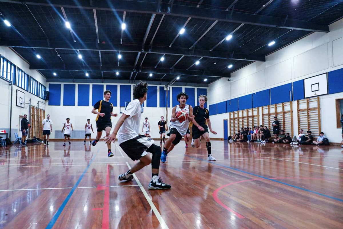 Studenti che giocano a basket nella palestra del Birkenhead College durante un anno all’estero in Nuova Zelanda.